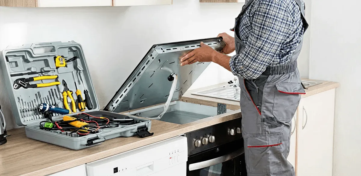 Handyman repairing a cooktop and checking wiring connections in Cedar Rapids, IA